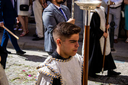 Carmona, Spain - June 19, 2022 Corpus Christi of Carmona, religious procession through the streets to Santa Maria Church, made up of religious statues, young children, christians and a music bandのeditorial素材