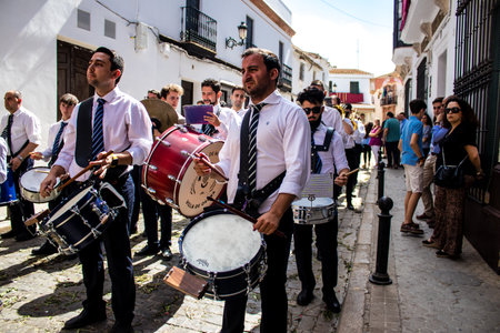 Carmona, Spain - June 19, 2022 Corpus Christi of Carmona, religious procession through the streets to Santa Maria Church, made up of religious statues, young children, christians and a music bandのeditorial素材