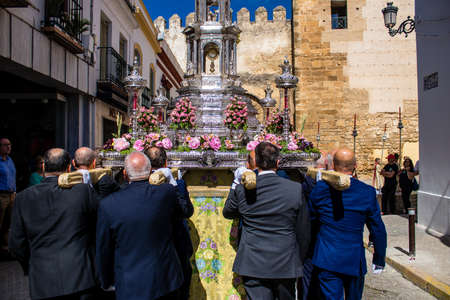 Carmona, Spain - June 19, 2022 Corpus Christi of Carmona, religious procession through the streets to Santa Maria Church, made up of religious statues, young children, christians and a music bandのeditorial素材