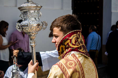 Carmona, Spain - June 19, 2022 Corpus Christi of Carmona, religious procession through the streets to Santa Maria Church, made up of religious statues, young children, christians and a music bandのeditorial素材