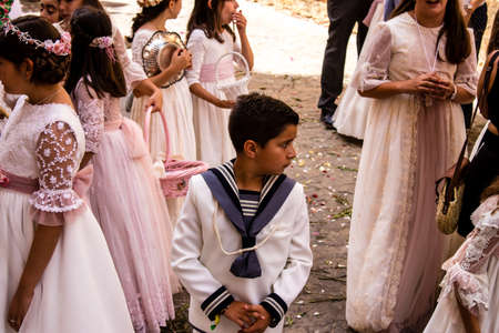 Carmona, Spain - June 19, 2022 Corpus Christi of Carmona, religious procession through the streets to Santa Maria Church, made up of religious statues, young children, christians and a music bandのeditorial素材