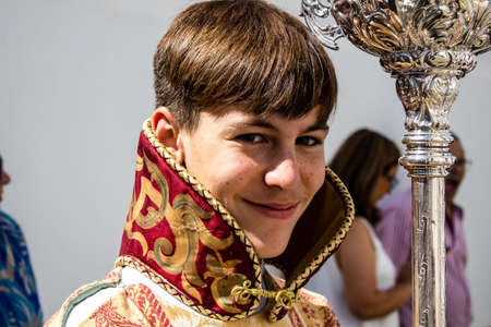 Carmona, Spain - June 19, 2022 Corpus Christi of Carmona, religious procession through the streets to Santa Maria Church, made up of religious statues, young children, christians and a music bandのeditorial素材