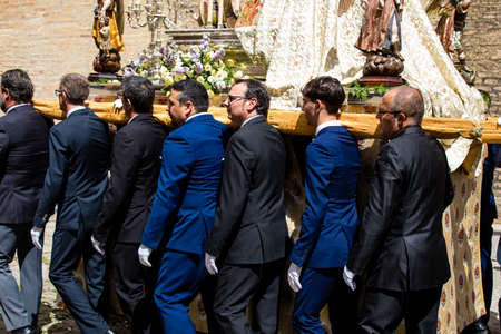 Carmona, Spain - June 19, 2022 Corpus Christi of Carmona, religious procession through the streets to Santa Maria Church, made up of religious statues, young children, christians and a music bandのeditorial素材