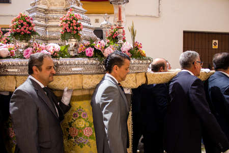 Carmona, Spain - June 19, 2022 Corpus Christi of Carmona, religious procession through the streets to Santa Maria Church, made up of religious statues, young children, christians and a music bandのeditorial素材