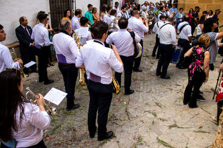 Carmona, Spain - June 19, 2022 Corpus Christi of Carmona, religious procession through the streets to Santa Maria Church, made up of religious statues, young children, christians and a music bandのeditorial素材