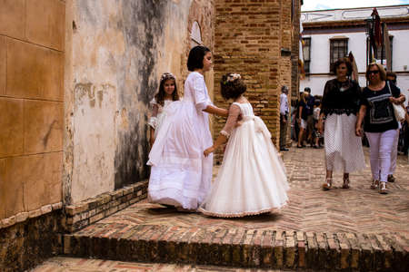 Carmona, Spain - June 19, 2022 Corpus Christi of Carmona, religious procession through the streets to Santa Maria Church, made up of religious statues, young children, christians and a music bandのeditorial素材