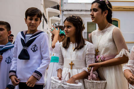 Carmona, Spain - June 19, 2022 Corpus Christi of Carmona, religious procession with young children walking through the streets to Santa Maria Churchのeditorial素材