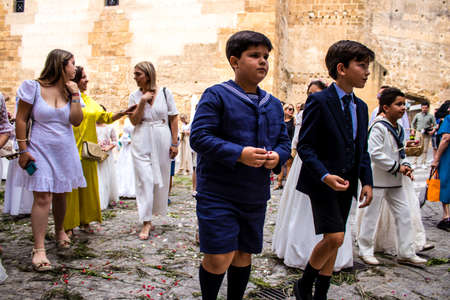 Carmona, Spain - June 19, 2022 Corpus Christi of Carmona, religious procession with young children walking through the streets to Santa Maria Churchのeditorial素材