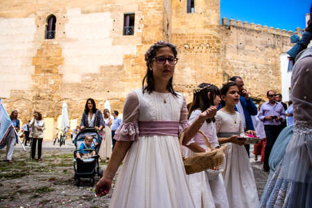 Carmona, Spain - June 19, 2022 Corpus Christi of Carmona, religious procession with young children walking through the streets to Santa Maria Churchのeditorial素材