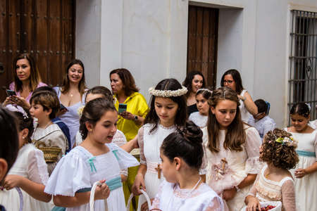 Carmona, Spain - June 19, 2022 Corpus Christi of Carmona, religious procession with young children walking through the streets to Santa Maria Churchのeditorial素材