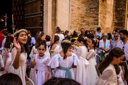 Carmona, Spain - June 19, 2022 Corpus Christi of Carmona, religious procession with young children walking through the streets to Santa Maria Churchのeditorial素材