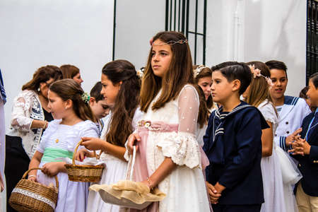 Carmona, Spain - June 19, 2022 Corpus Christi de Carmona, religious procession with young children through the streets to Santa Maria Churchのeditorial素材