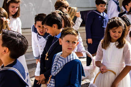 Carmona, Spain - June 19, 2022 Corpus Christi de Carmona, religious procession with young children walking through the streets to Santa Maria Churchのeditorial素材