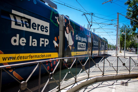 Seville, Spain - July 04, 2022 Modern electric tram for passengers rolling through the streets of Seville during the coronavirus outbreak hitting Spain, wearing a mask is mandatoryのeditorial素材