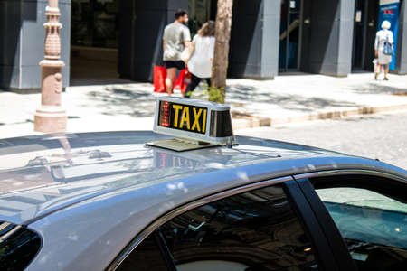 Seville, Spain - July 04, 2022 Taxi driving through the streets of Seville during the coronavirus outbreak hitting Spain, wearing a mask is mandatoryのeditorial素材