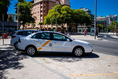Seville, Spain - July 04, 2022 Taxi driving through the streets of Seville during the coronavirus outbreak hitting Spain, wearing a mask is mandatoryのeditorial素材