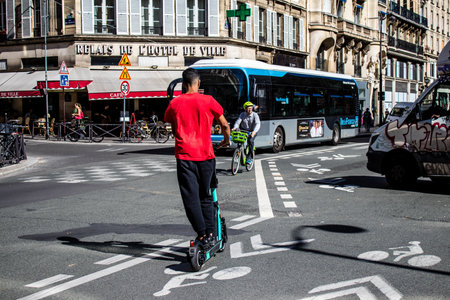 Paris, France - September 14, 2022 People rolling with an electric scooter in the streets of Paris, operating with a small utility internal combustion engines and a deck in the centerのeditorial素材