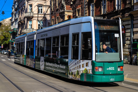 Krakow, Poland - October 08, 2022 Modern electric tram driving in the streets of Krakow and part of the transport system of the city, the fares are not expensiveのeditorial素材