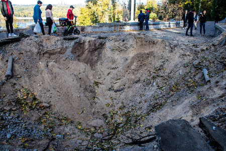Aftermath of massive Russian missile attacks, a public garden near the Friendship Arch of Kyiv in the city center was hit hard. Missiles hit in 4 places in the city of Kyiv. 9 people died and 36 people were injured. Russia threatens more strikes after misのeditorial素材