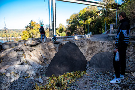 Aftermath of massive Russian missile attacks, a public garden near the Friendship Arch of Kyiv in the city center was hit hard. Missiles hit in 4 places in the city of Kyiv. 9 people died and 36 people were injured. Russia threatens more strikes after misのeditorial素材