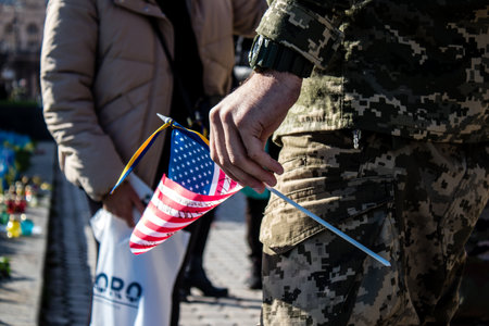 3 soldiers of the foreign legion in Ukraine, of American, Canadian and Belgian nationality pay homage to one of their killed in action in Kherson during the fights with the Russian army. A small flag with the name of the dead soldier is planted in the maiのeditorial素材