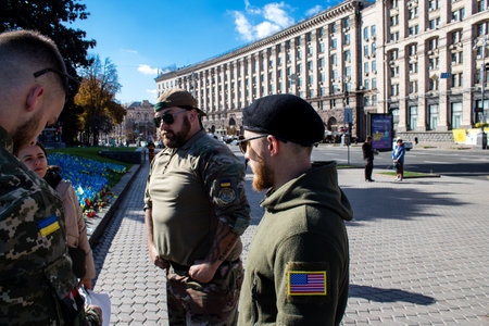 3 soldiers of the foreign legion in Ukraine, of American, Canadian and Belgian nationality pay homage to one of their killed in action in Kherson during the fights with the Russian army. A small flag with the name of the dead soldier is planted in the maiのeditorial素材