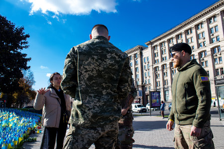 3 soldiers of the foreign legion in Ukraine, of American, Canadian and Belgian nationality pay homage to one of their killed in action in Kherson during the fights with the Russian army. A small flag with the name of the dead soldier is planted in the maiのeditorial素材