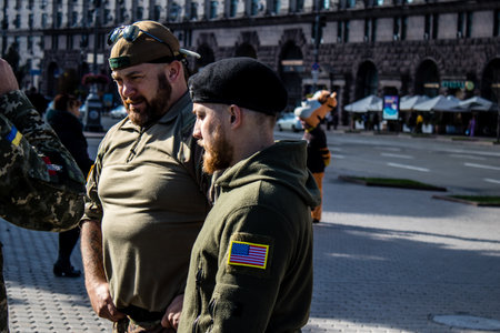 3 soldiers of the foreign legion in Ukraine, of American, Canadian and Belgian nationality pay homage to one of their killed in action in Kherson during the fights with the Russian army. A small flag with the name of the dead soldier is planted in the maiのeditorial素材