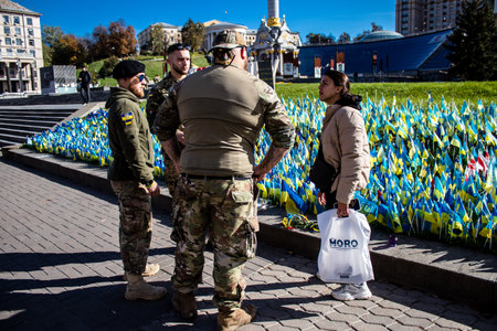3 soldiers of the foreign legion in Ukraine, of American, Canadian and Belgian nationality pay homage to one of their killed in action in Kherson during the fights with the Russian army. A small flag with the name of the dead soldier is planted in the maiのeditorial素材