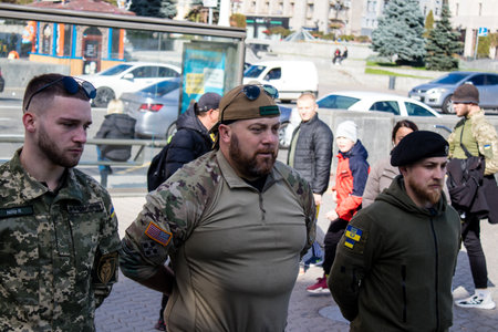 3 soldiers of the foreign legion in Ukraine, of American, Canadian and Belgian nationality pay homage to one of their killed in action in Kherson during the fights with the Russian army. A small flag with the name of the dead soldier is planted in the maiのeditorial素材