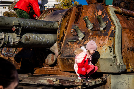 Ukrainian children have fun on the destroyed Russian military equipment, they use it like a playground. The destroyed Russian military equipment exhibition is an open air exhibition.のeditorial素材