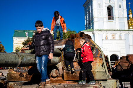Ukrainian children have fun on the destroyed Russian military equipment, they use it like a playground. The destroyed Russian military equipment exhibition is an open air exhibition.のeditorial素材