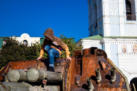 Ukrainian children have fun on the destroyed Russian military equipment, they use it like a playground. The destroyed Russian military equipment exhibition is an open air exhibition.のeditorial素材