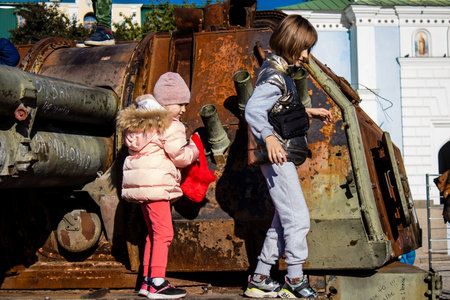 Ukrainian children have fun on the destroyed Russian military equipment, they use it like a playground. The destroyed Russian military equipment exhibition is an open air exhibition.のeditorial素材