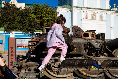 Ukrainian children have fun on the destroyed Russian military equipment, they use it like a playground. The destroyed Russian military equipment exhibition is an open air exhibition.のeditorial素材