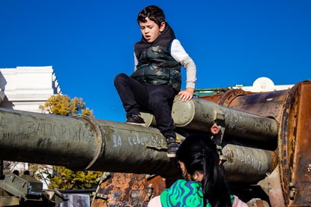 Ukrainian children have fun on the destroyed Russian military equipment, they use it like a playground. The destroyed Russian military equipment exhibition is an open air exhibition.のeditorial素材