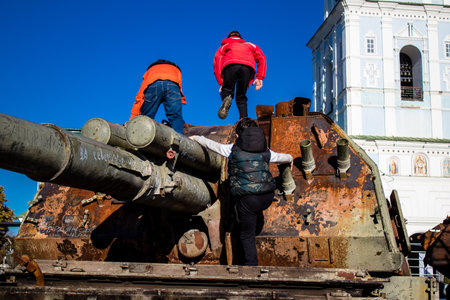 Ukrainian children have fun on the destroyed Russian military equipment, they use it like a playground. The destroyed Russian military equipment exhibition is an open air exhibition.のeditorial素材