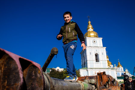 Ukrainian children have fun on the destroyed Russian military equipment, they use it like a playground. The destroyed Russian military equipment exhibition is an open air exhibition.のeditorial素材
