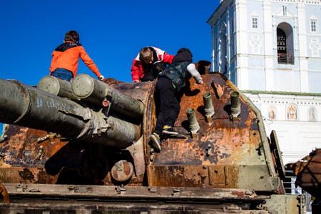 Ukrainian children have fun on the destroyed Russian military equipment, they use it like a playground. The destroyed Russian military equipment exhibition is an open air exhibition.のeditorial素材