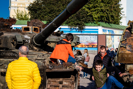 Ukrainian children have fun on the destroyed Russian military equipment, they use it like a playground. The destroyed Russian military equipment exhibition is an open air exhibition.のeditorial素材