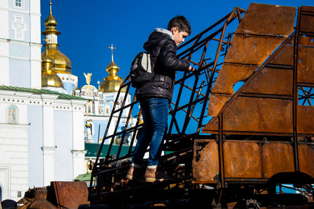 Ukrainian children have fun on the destroyed Russian military equipment, they use it like a playground. The destroyed Russian military equipment exhibition is an open air exhibition.のeditorial素材