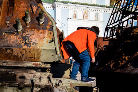 Ukrainian children have fun on the destroyed Russian military equipment, they use it like a playground. The destroyed Russian military equipment exhibition is an open air exhibition.のeditorial素材