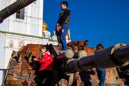 Ukrainian children have fun on the destroyed Russian military equipment, they use it like a playground. The destroyed Russian military equipment exhibition is an open air exhibition.のeditorial素材