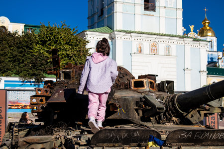 Ukrainian children have fun on the destroyed Russian military equipment, they use it like a playground. The destroyed Russian military equipment exhibition is an open air exhibition.のeditorial素材