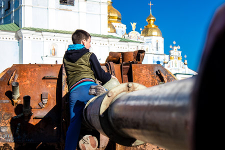 Ukrainian children have fun on the destroyed Russian military equipment, they use it like a playground. The destroyed Russian military equipment exhibition is an open air exhibition.のeditorial素材