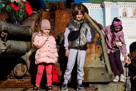 Ukrainian children have fun on the destroyed Russian military equipment, they use it like a playground. The destroyed Russian military equipment exhibition is an open air exhibition.のeditorial素材