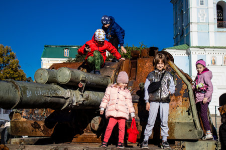 Ukrainian children have fun on the destroyed Russian military equipment, they use it like a playground. The destroyed Russian military equipment exhibition is an open air exhibition.のeditorial素材