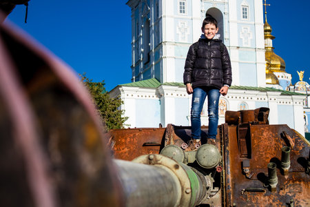 Ukrainian children have fun on the destroyed Russian military equipment, they use it like a playground. The destroyed Russian military equipment exhibition is an open air exhibition.のeditorial素材