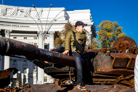 Ukrainian children have fun on the destroyed Russian military equipment, they use it like a playground. The destroyed Russian military equipment exhibition is an open air exhibition.のeditorial素材