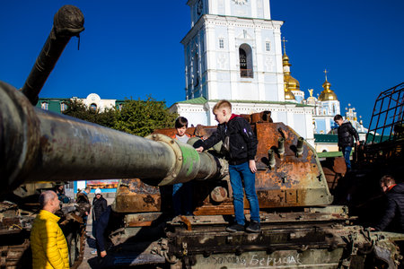 Ukrainian children have fun on the destroyed Russian military equipment, they use it like a playground. The destroyed Russian military equipment exhibition is an open air exhibition.のeditorial素材